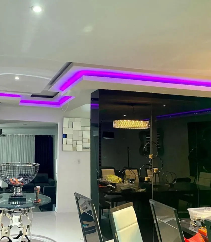 Comedor residencial con plafón escalonado iluminado por tira LED morada