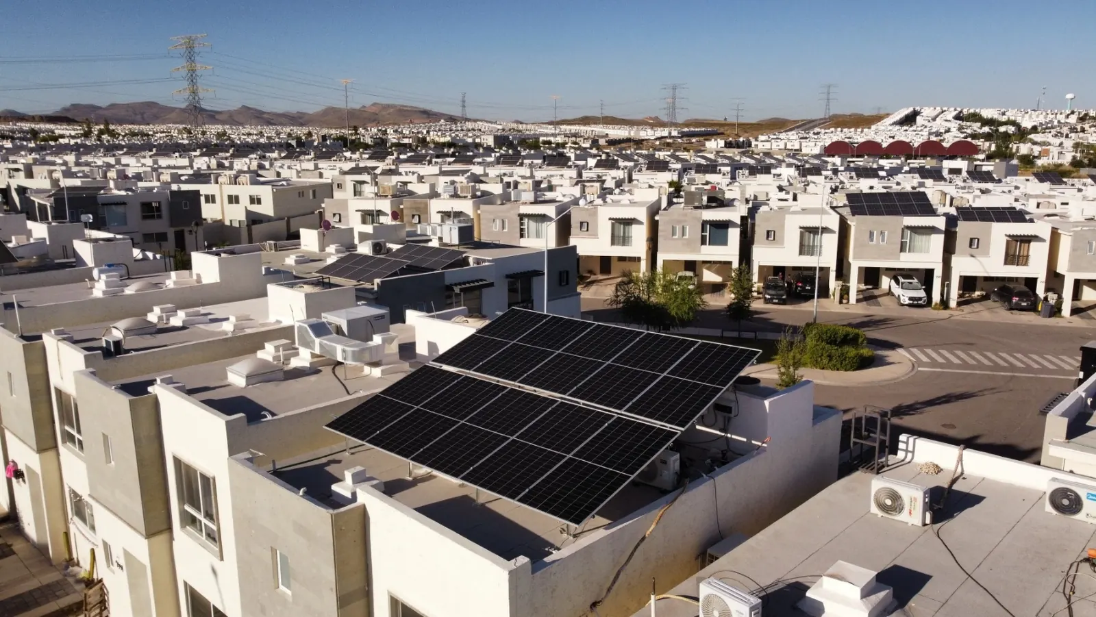Vista aérea de paneles solares en azotea de vivienda dentro de un fraccionamiento residencial