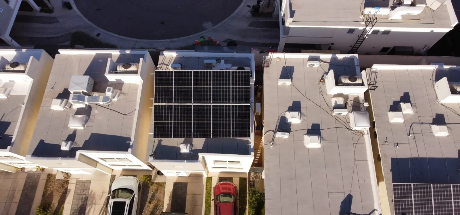 Toma cenital de azoteas residenciales con paneles solares instalados junto a equipos de clima