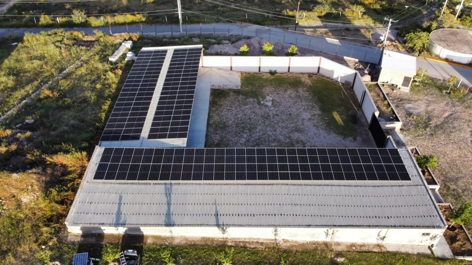 Vista aérea de paneles solares dispuestos en forma de L sobre el techo de un inmueble